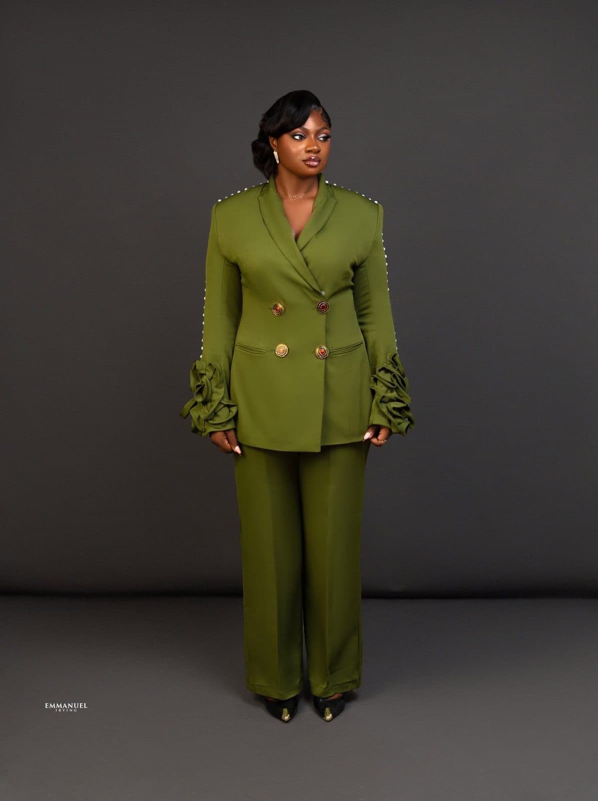 A woman in a tailored olive blazer suit